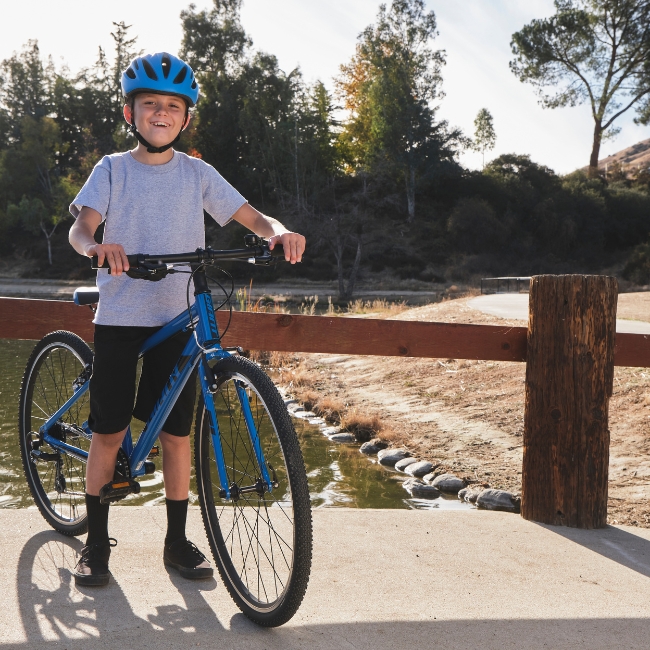 smiling child with giant arx 26 junior bike